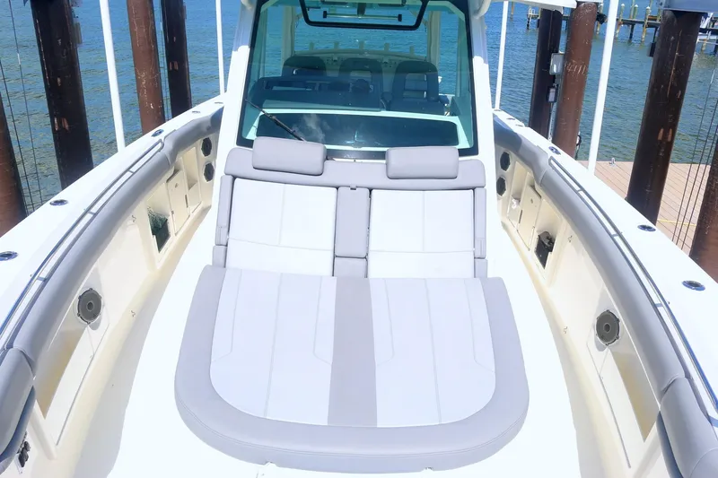 Slide: The Image of 2022 Boston Whaler 380 Outrage boat interior with cushioned seating and ocean view. - 11
