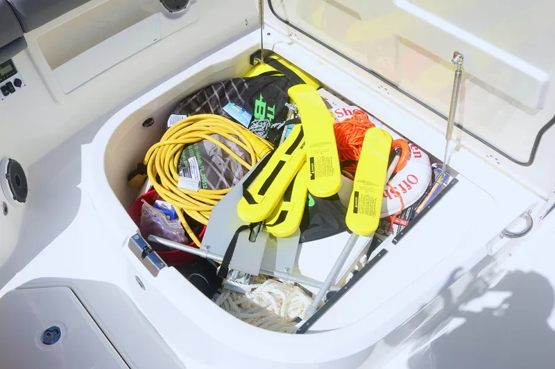 Slide: The Image of Storage compartment on 2022 Boston Whaler 380 Outrage filled with boating equipment. - 12
