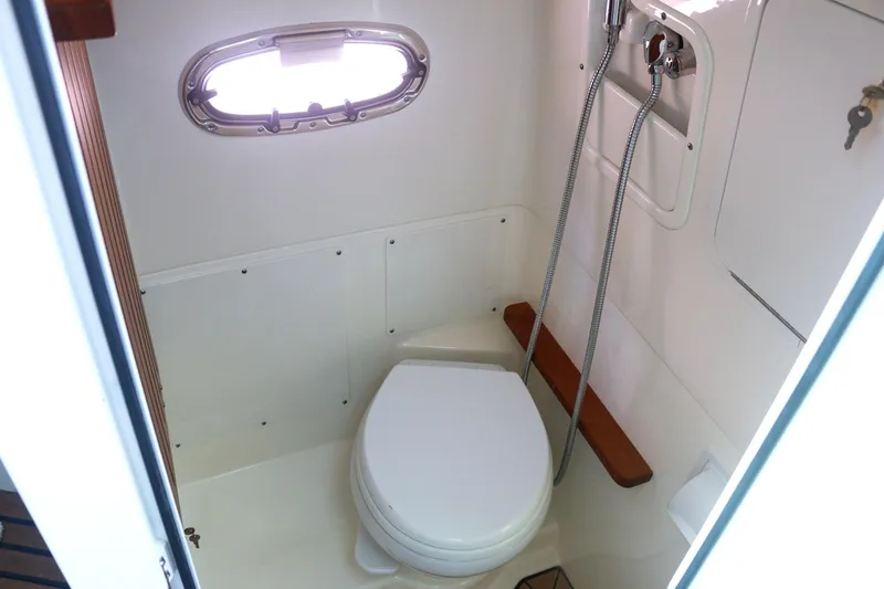Slide: The Image of 2022 Boston Whaler 380 Outrage boat bathroom with toilet and showerhead. - 16
