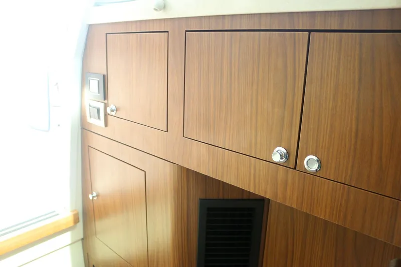 Slide: The Image of Interior cabinetry of 2022 Boston Whaler 380 Outrage, featuring sleek wooden finish and modern design. - 18