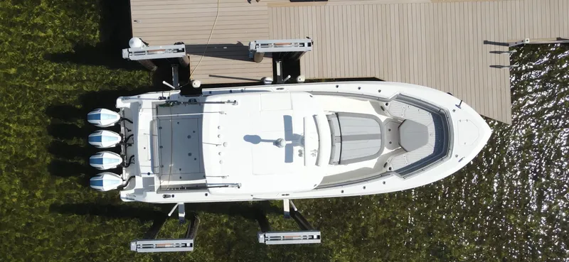 Slide: The Image of Aerial view of 2022 Boston Whaler 380 Outrage docked by a wooden pier. - 2