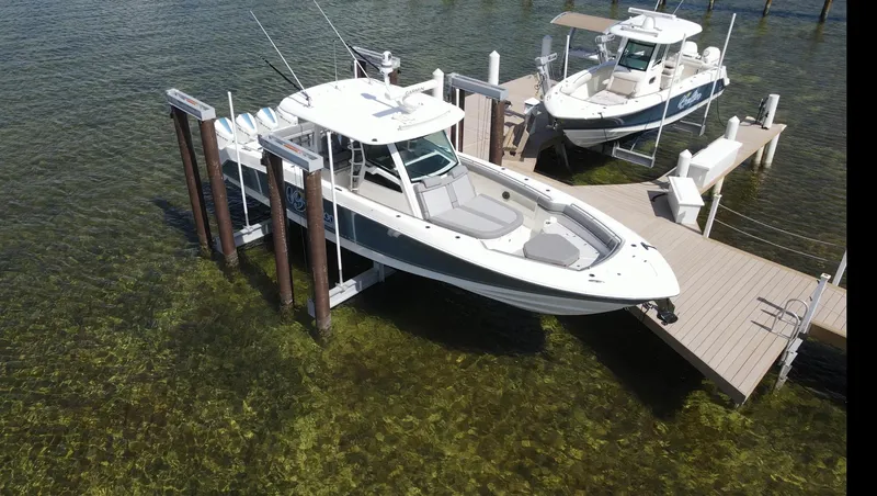 Slide: The Image of 2022 Boston Whaler 380 Outrage boat docked on clear water, aerial view. - 3