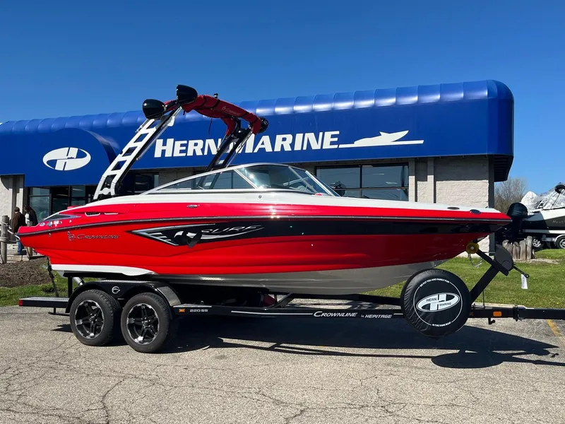The Image of 2024 Crownline 220 SS SURF boat in vibrant red on trailer, displayed at Hern Marine. - 0