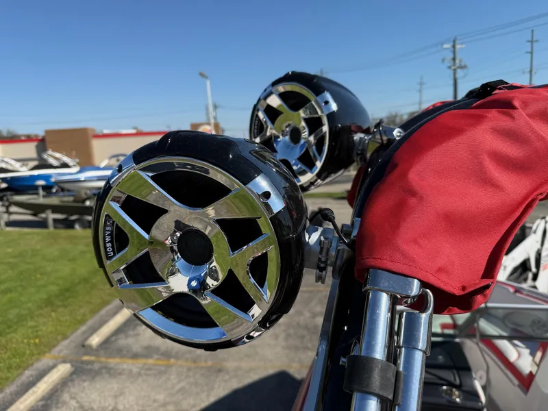 Slide: The Image of 2024 Crownline 220 SS SURF boat speakers with chrome accents and red cover. - 11