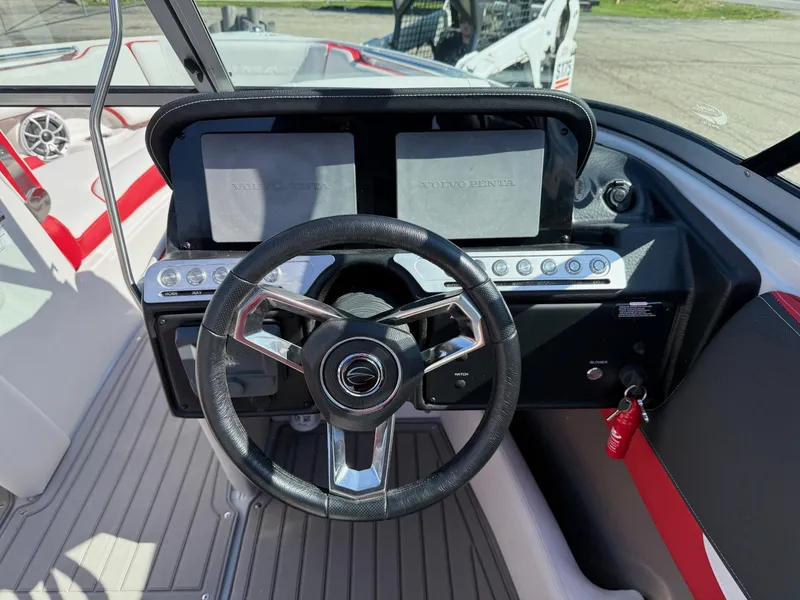 Slide: The Image of 2024 Crownline 220 SS SURF boat dashboard with steering wheel and control panels. - 6
