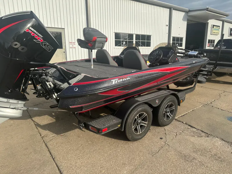 Slide: The Image of 2023 Triton 18 TrX boat with red and black design on a trailer. - 0
