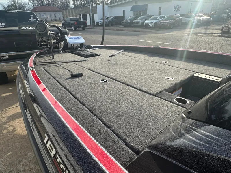 Slide: The Image of 2023 Triton 18 TrX boat deck with carpeted surface and storage compartments. - 12