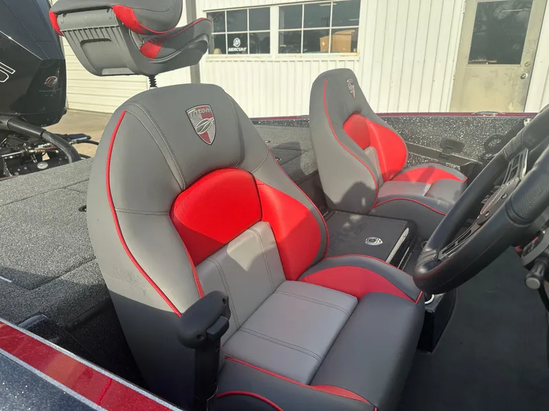Slide: The Image of 2023 Triton 18 TrX boat interior with red and gray seats, steering wheel visible. - 5