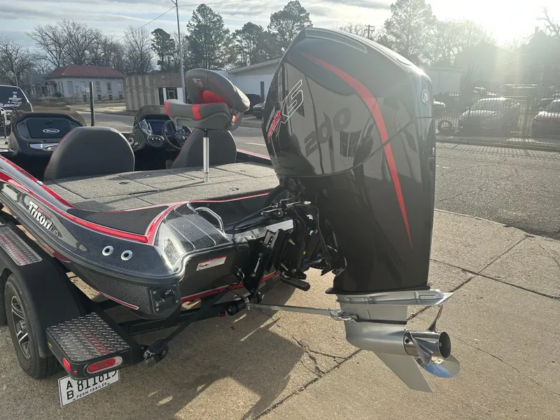 Slide: The Image of 2023 Triton 18 TrX boat with powerful outboard motor, parked on a sunny day. - 9