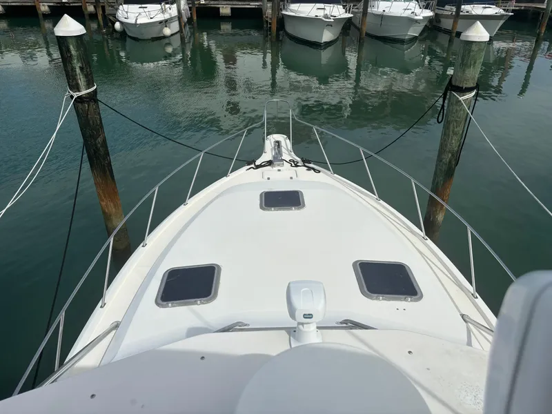 The Image of 1995 Tiara Yachts 3600 Open docked, view from bow, surrounded by calm marina waters. - 0
