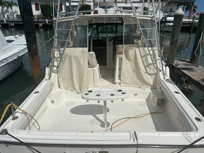 Slide: The Image of 1995 Tiara Yachts 3600 Open at dock, featuring spacious deck and fishing setup. - 12