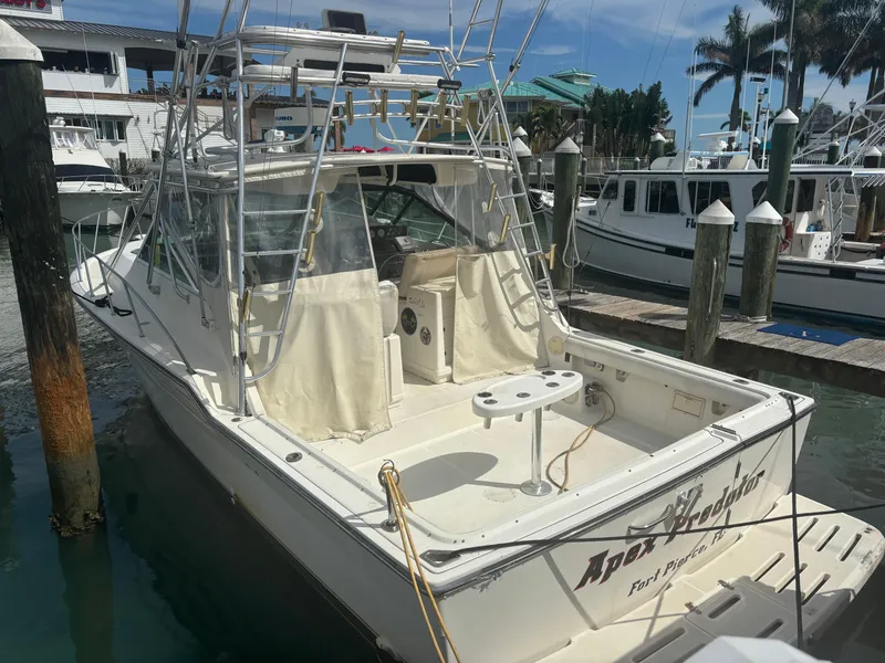Slide: The Image of 1995 Tiara Yachts 3600 Open docked, featuring a spacious deck and fishing equipment. - 13