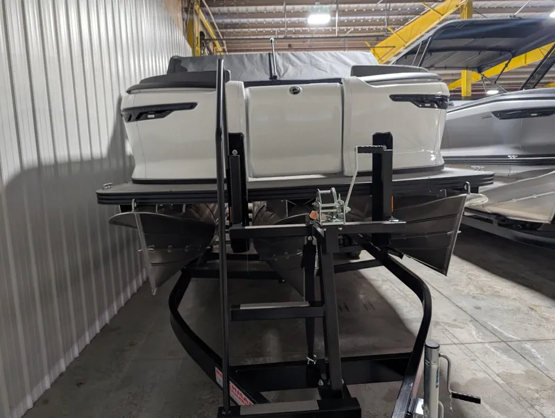 Slide: The Image of 2025 Manitou 22 CRUISE boat on trailer in indoor storage facility. - 1