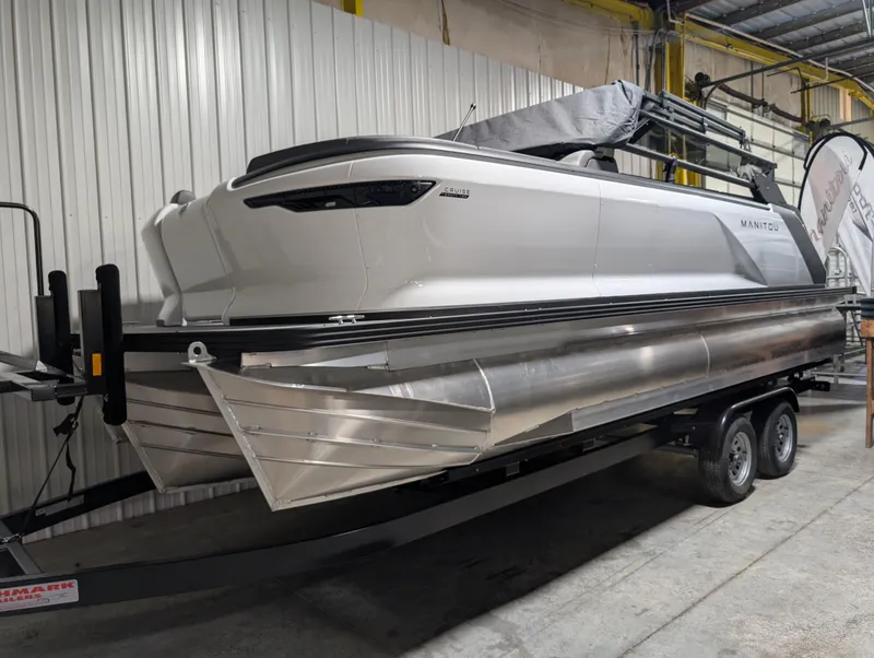Slide: The Image of 2025 Manitou 22 CRUISE pontoon boat on trailer in indoor storage. - 2