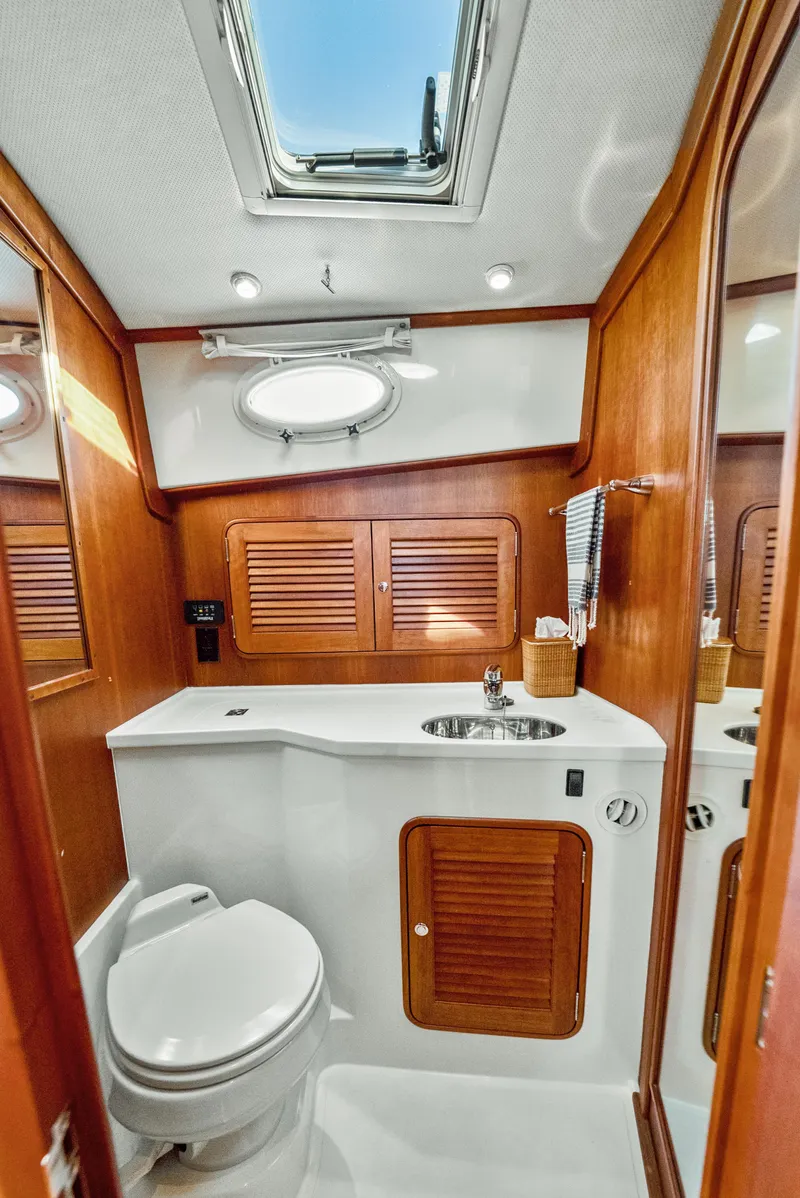 Slide: The Image of 2008 Hinckley Talaria 44 yacht bathroom with wooden accents and skylight. - 10