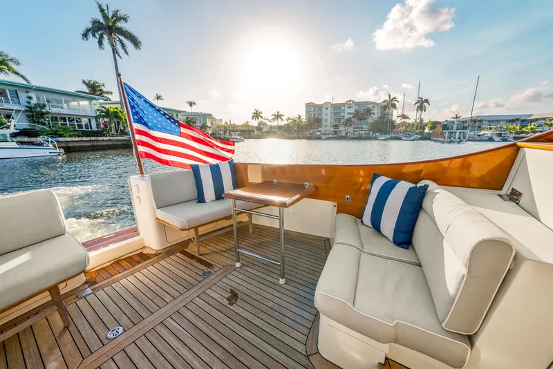 Slide: The Image of 2008 Hinckley Talaria 44 yacht deck with seating, American flag, and waterfront view. - 14