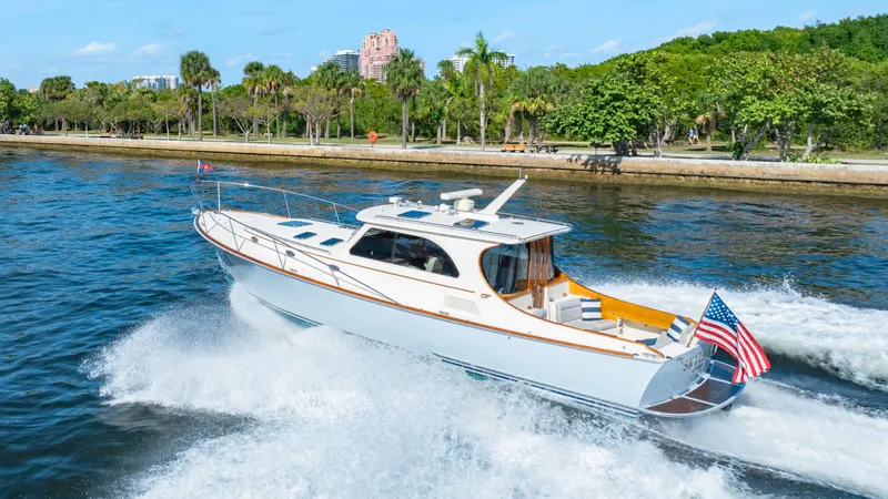 Slide: The Image of 2008 Hinckley Talaria 44 yacht cruising on a scenic waterway with lush greenery. - 17