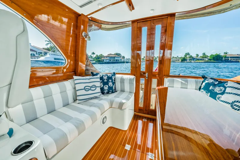 Slide: The Image of Interior of 2008 Hinckley Talaria 44 yacht with elegant wood finish and striped seating. - 2