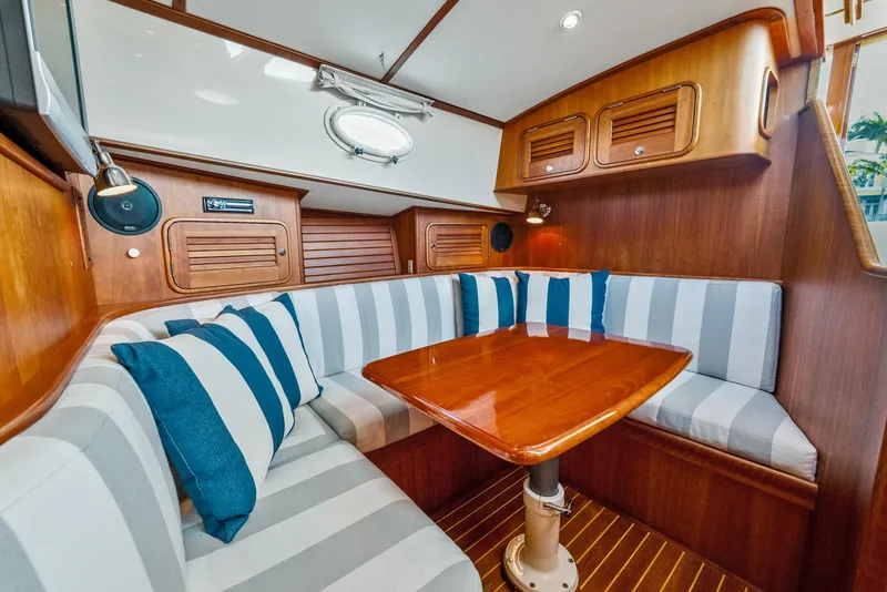Slide: The Image of Interior of 2008 Hinckley Talaria 44 yacht with striped seating and wooden table. - 9