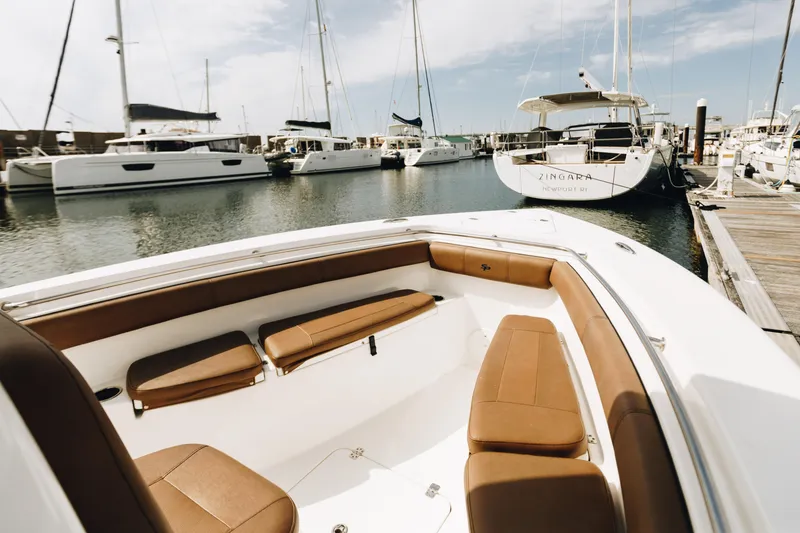 Slide: The Image of 2019 Sea Pro 259 Center Console boat docked in a marina with other vessels. - 12