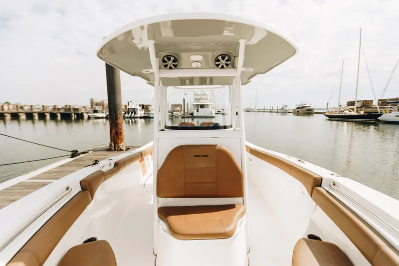 Slide: The Image of 2019 Sea Pro 259 Center Console boat docked at marina, featuring spacious seating. - 14