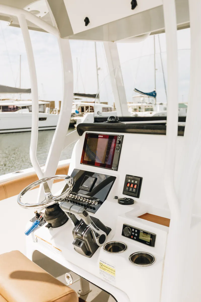 Slide: The Image of 2019 Sea Pro 259 Center Console boat dashboard with steering wheel and navigation equipment. - 3
