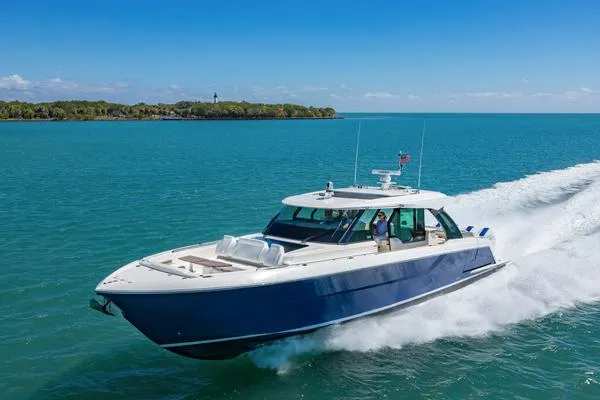 Slide: The Image of 2025 Tiara Yachts 56 LS cruising on clear blue water under a sunny sky. - 0