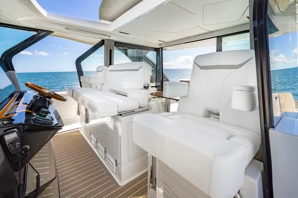 Slide: The Image of 2025 Tiara Yachts 56 LS interior with luxurious white seating and ocean view. - 11