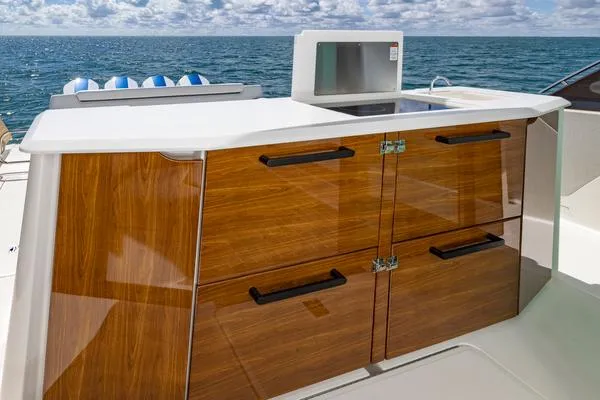 Slide: The Image of 2025 Tiara Yachts 56 LS outdoor kitchen with wooden cabinetry and ocean view. - 15