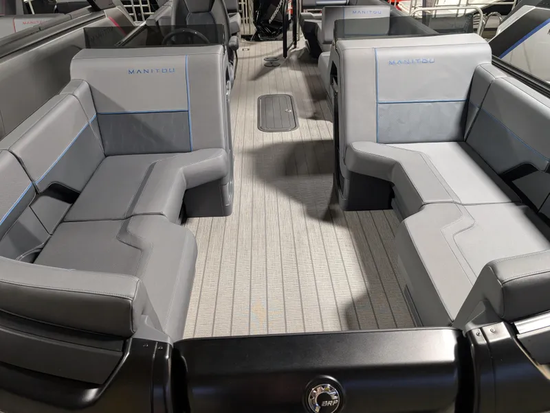 Slide: The Image of 2025 Manitou Explore boat interior with gray seating and modern design. - 12