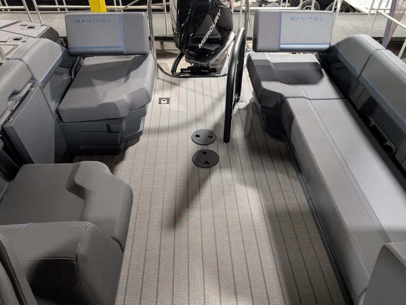 Slide: The Image of 2025 Manitou Explore boat interior with gray seating and modern design. - 14