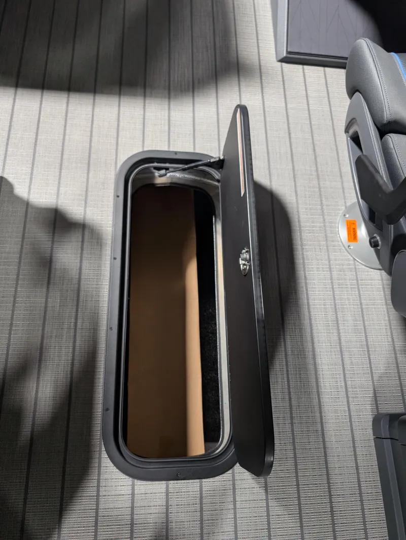Slide: The Image of Open storage compartment in 2025 Manitou Explore boat interior. - 15