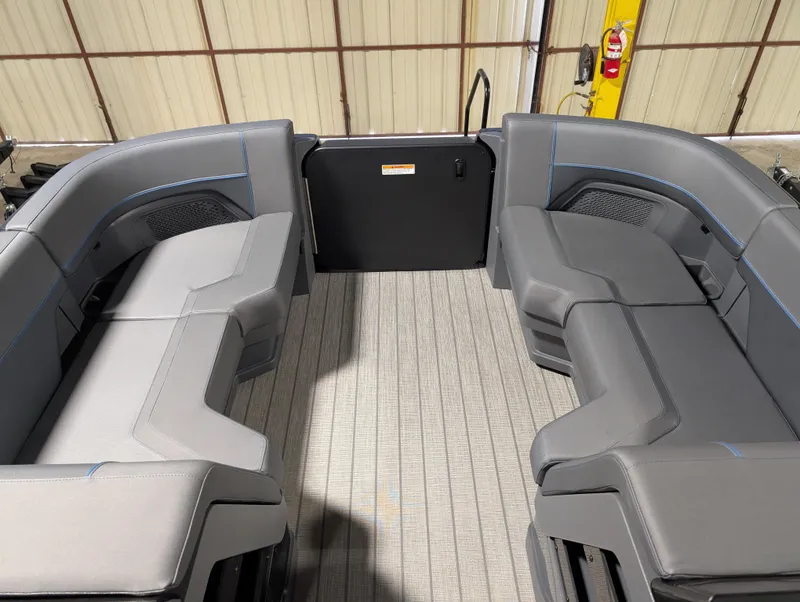 Slide: The Image of 2025 Manitou Explore boat interior with gray seating and spacious layout. - 8