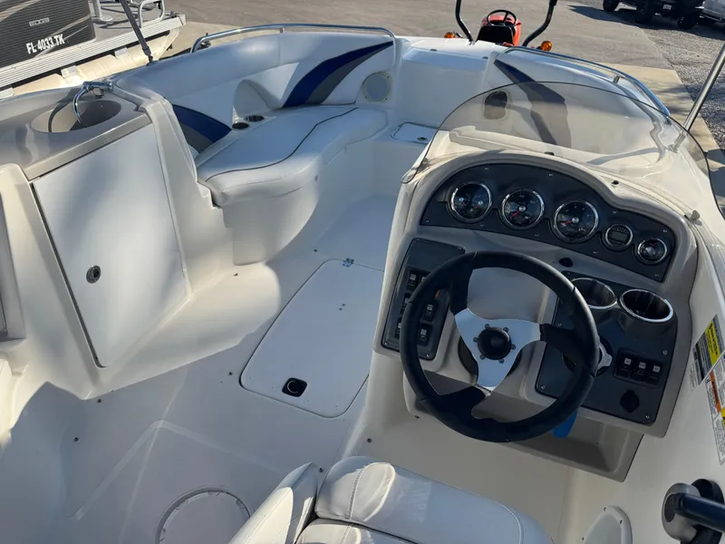 The Image of 2012 Hurricane SunDeck Sport 200 OB boat on trailer with Yamaha outboard motor. - 1