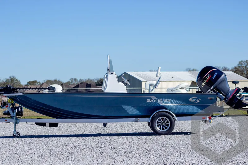 Slide: The Image of 2025 G3 Bay 19 GX boat on trailer, blue hull, outdoor setting. - 8