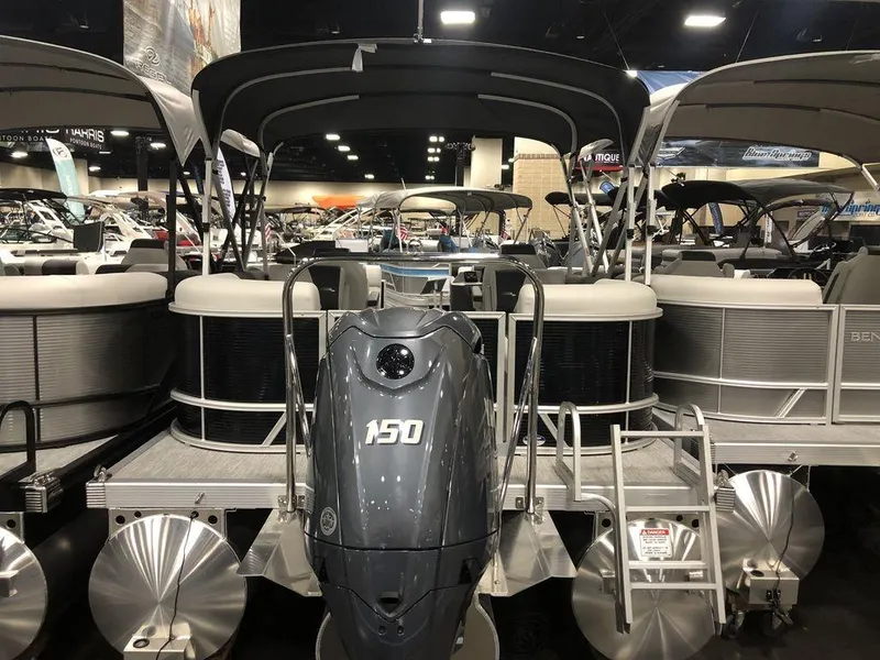 Slide: The Image of 2025 Bennington S Quad Bench 22 SSR pontoon boat with 150 HP engine at a boat show. - 6