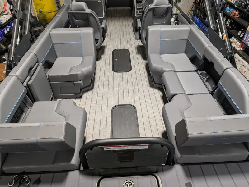 Slide: The Image of 2025 Manitou Explore Dual Engine boat interior with spacious gray seating and modern design. - 10