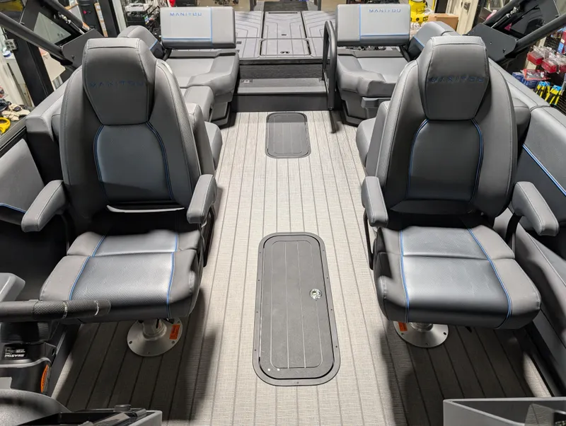 Slide: The Image of Interior of 2025 Manitou Explore Dual Engine boat with modern seating and sleek design. - 14