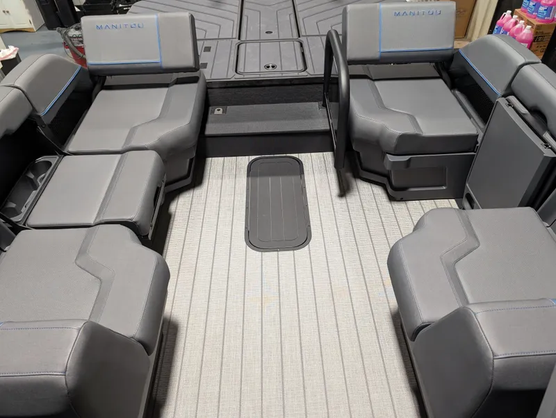 Slide: The Image of 2025 Manitou Explore Dual Engine boat interior with gray seating and modern design. - 15