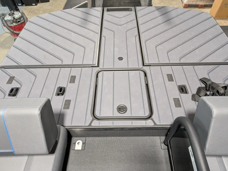 Slide: The Image of 2025 Manitou Explore Dual Engine boat deck with sleek, modern design and storage compartments. - 16