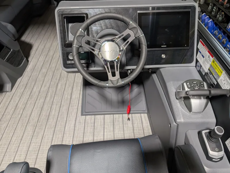Slide: The Image of Steering console of 2025 Manitou Explore Dual Engine boat with modern controls and display. - 17