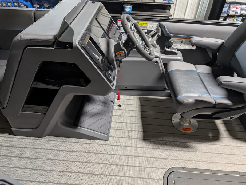 Slide: The Image of 2025 Manitou Explore Dual Engine boat interior with modern steering and seating. - 20