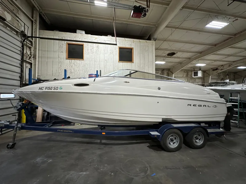 Slide: The Image of 2001 Regal 2350 LSC boat on trailer in indoor storage facility. - 1