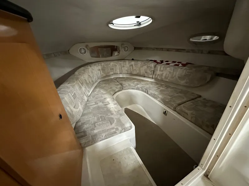 Slide: The Image of 2001 Regal 2350 LSC cabin interior with cushioned seating and portholes. - 10