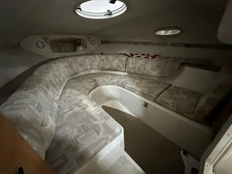 Slide: The Image of 2001 Regal 2350 LSC boat interior with cushioned seating and porthole windows. - 11