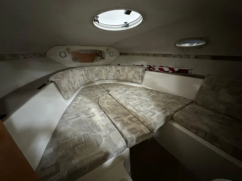 Slide: The Image of 2001 Regal 2350 LSC boat interior with cushioned seating and porthole windows. - 14