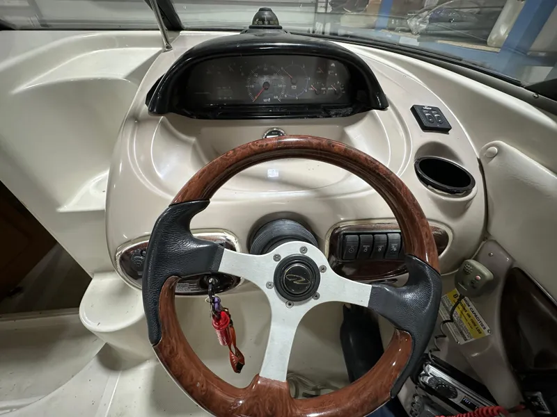 Slide: The Image of 2001 Regal 2350 LSC boat dashboard with wood-accented steering wheel and instrument panel. - 9