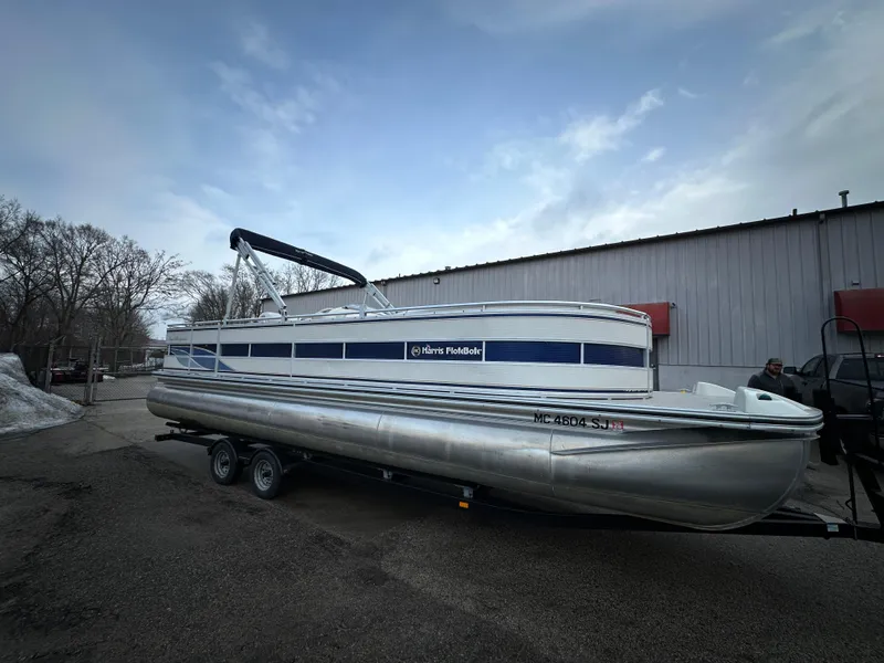 Slide: The Image of 2003 Harris FloteBote 260 Royal Heritage pontoon boat on trailer, parked outdoors. - 4