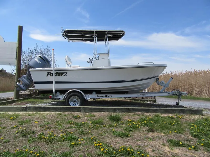 Slide: The Image of 2025 Parker 18SE Center Console boat on trailer, parked outdoors under blue sky. - 1