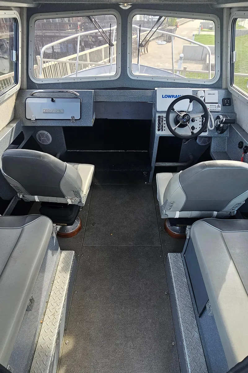 Slide: The Image of Interior of 2018 KingFisher 2325 Coastal Express boat, featuring steering wheel and seating. - 13
